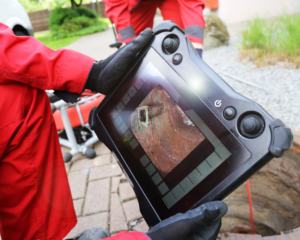 Technician performing a sewer line inspection with a camera to ensure proper maintenance.